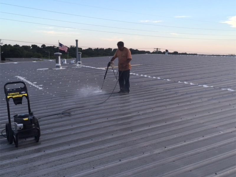 A man coating a roof