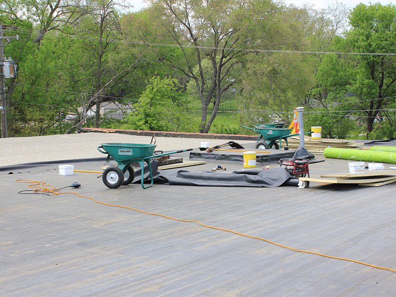 Wheelbarrows and TPO tools on a flat roof